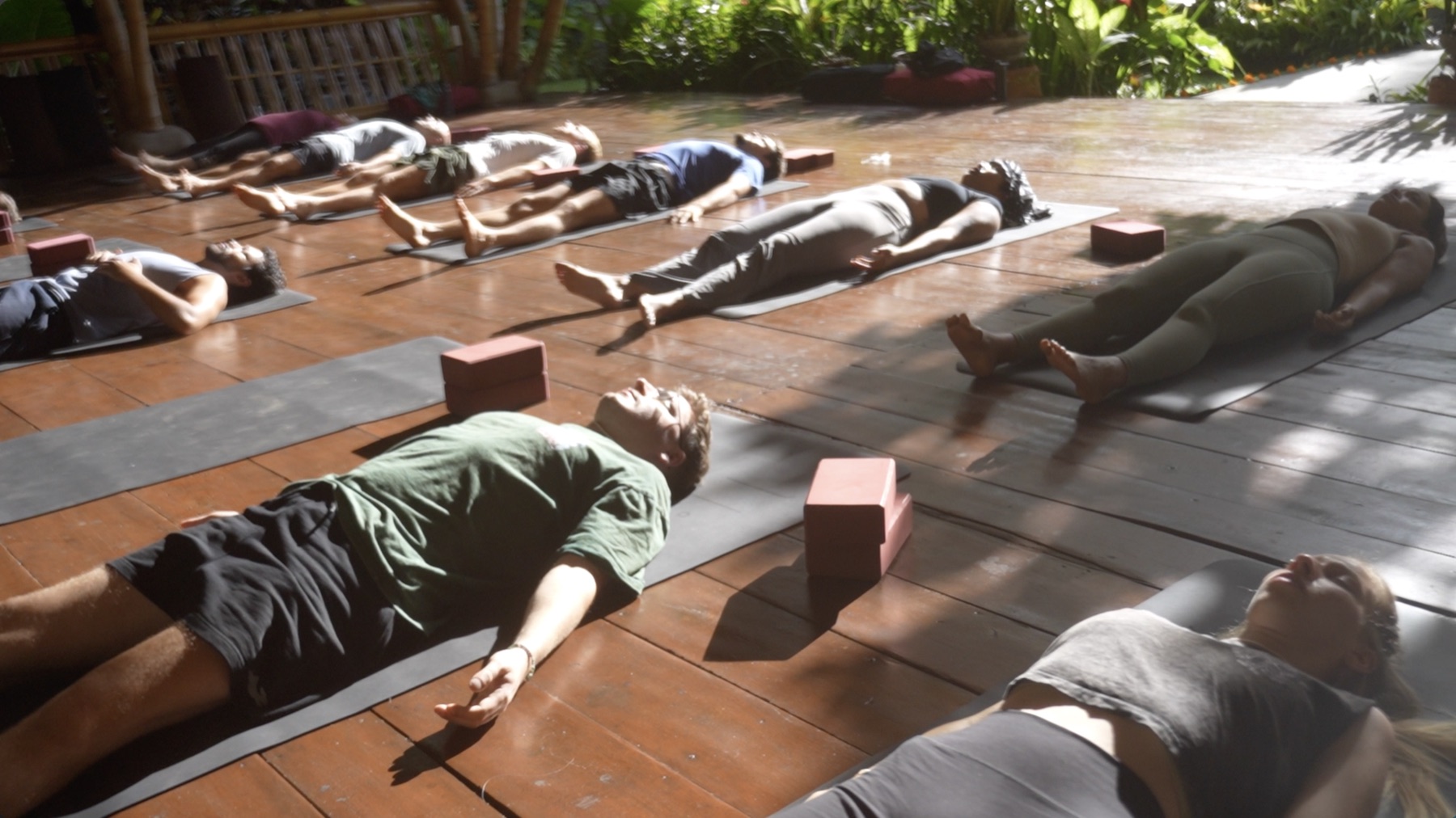 Participants resting on mats together during a guided breathwork practice