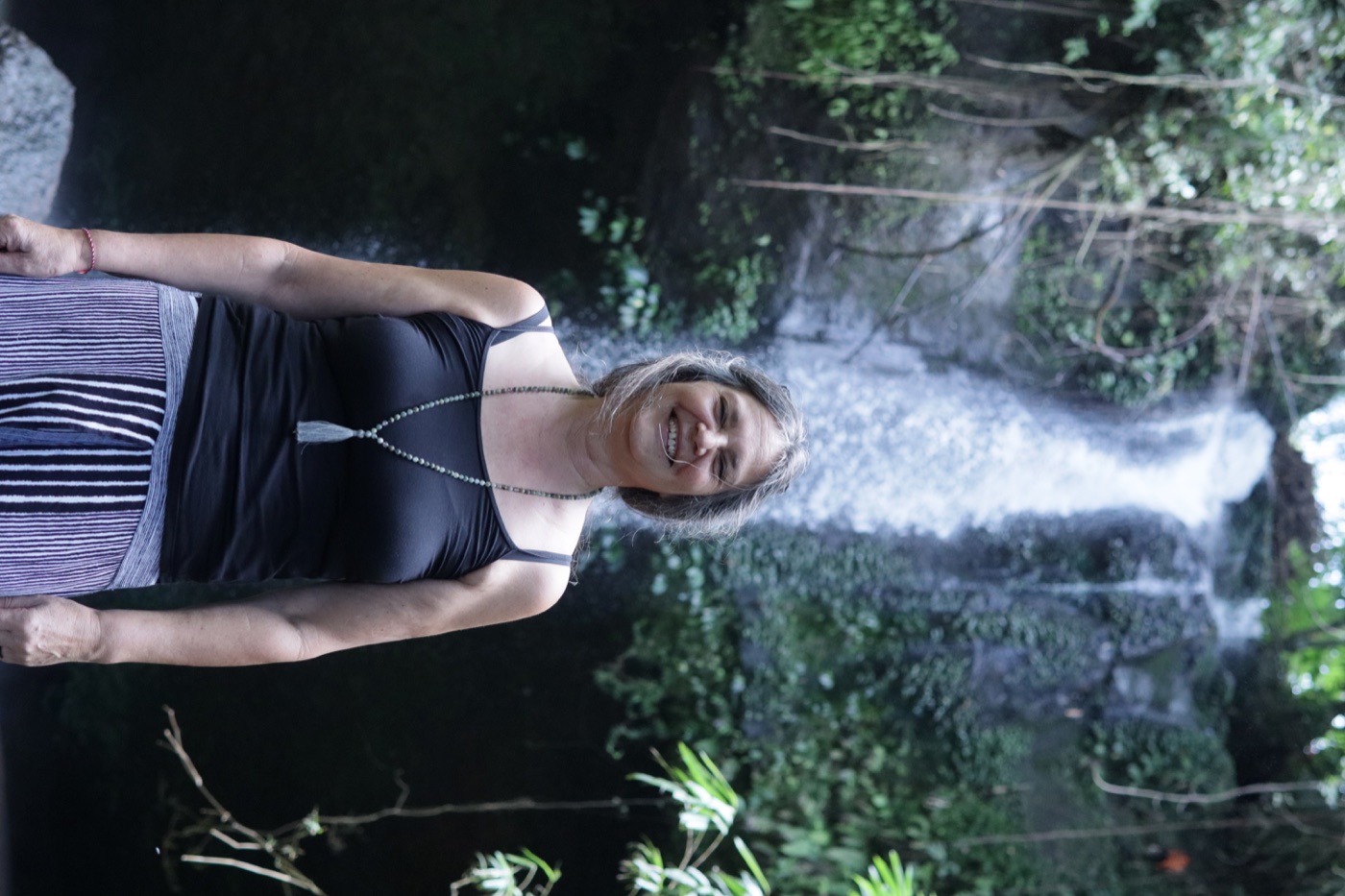 A participant smiling in front of a waterfall in West Bali